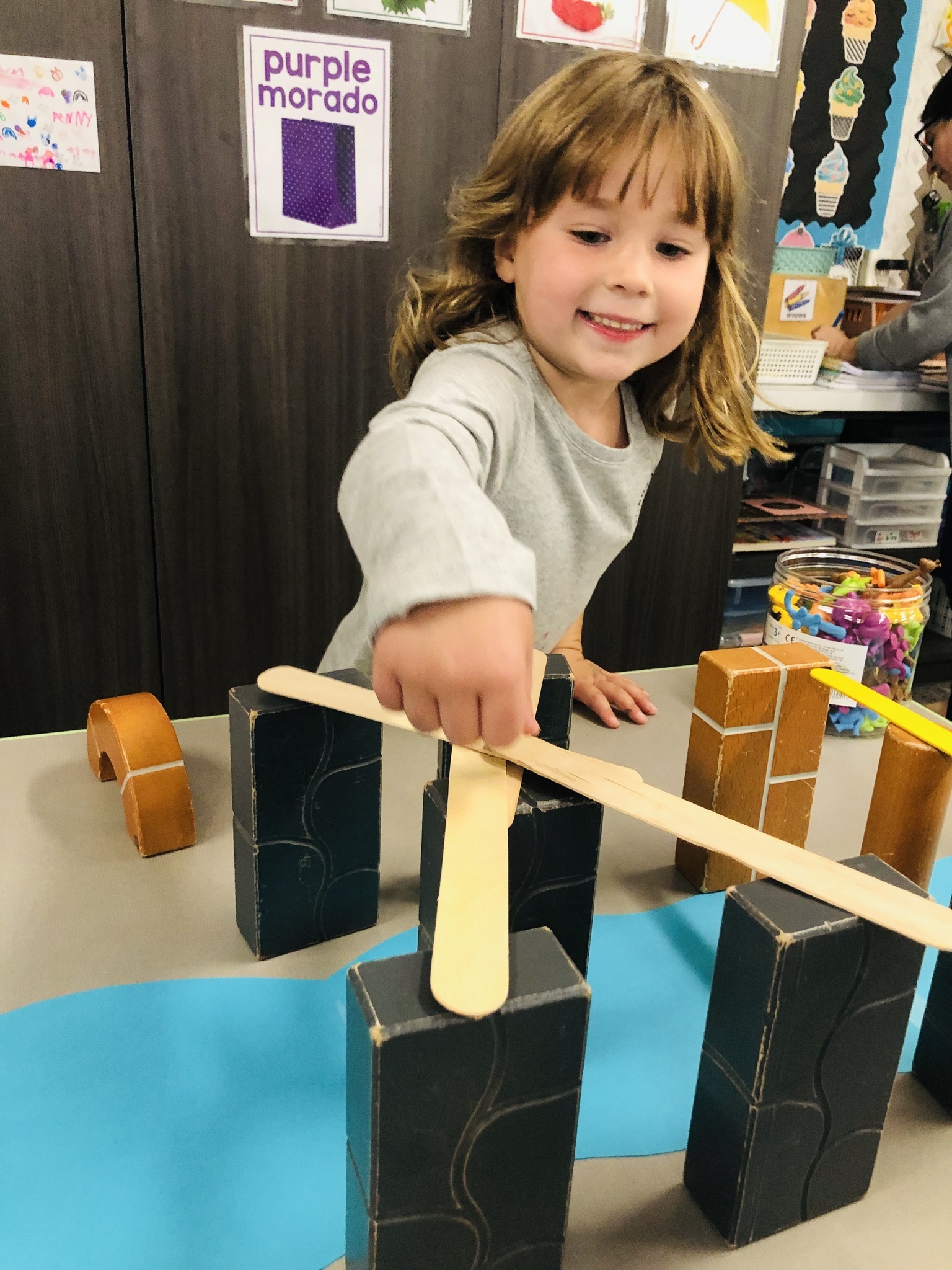 Young 5 student planning and building her bridge.